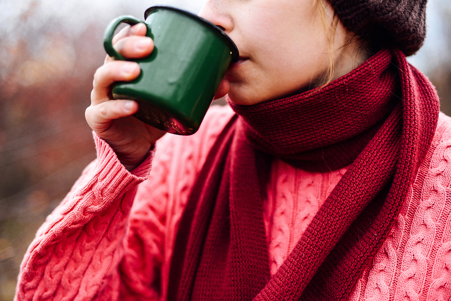 Woman sipping from a travel mug