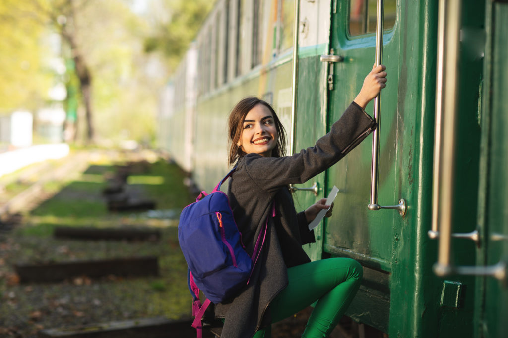 Woman boarding a train, which is eco-friendly