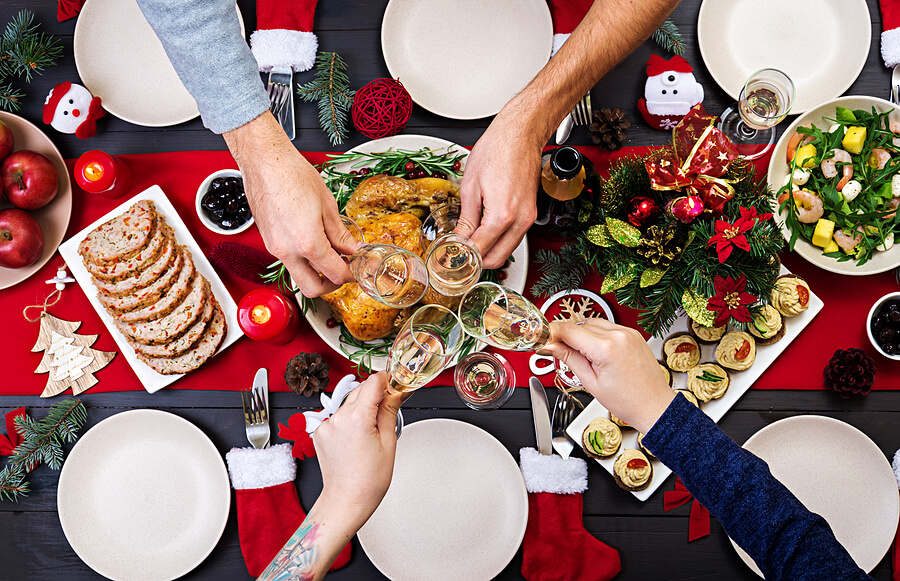 Family saying cheers with champagne flutes over table of Christmas dinner