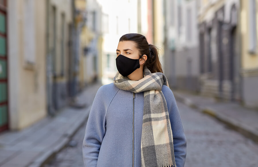 woman wearing coat and reusable fabric face mask