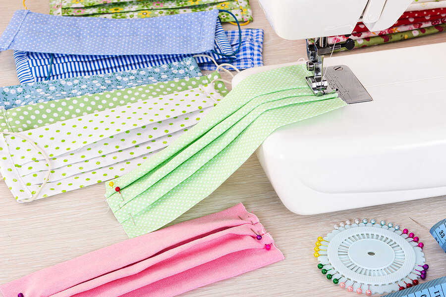 Face masks being customised with a sewing machine.