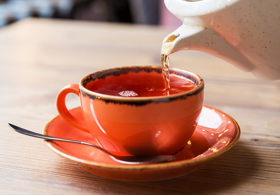 Tea cup with hot tea pot