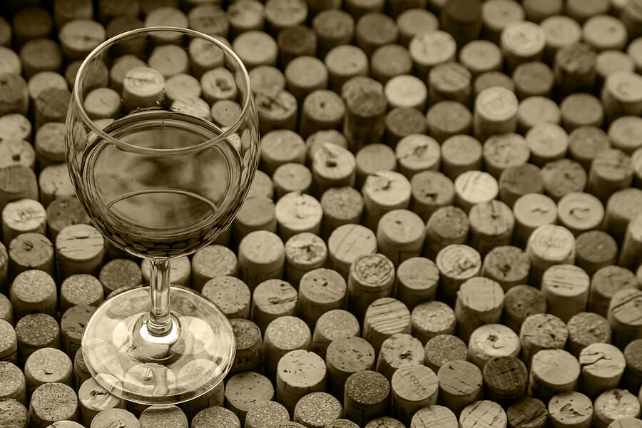 Glass of wine standing on table made from used wine corks