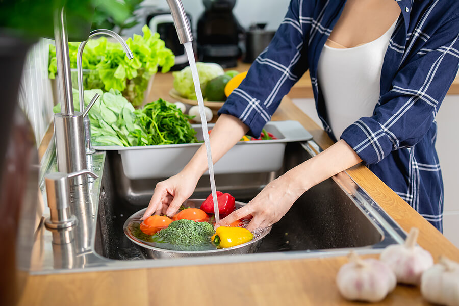 Close up Asian healthy woman washing vegetable above kitchen sink, preparing eat cleaning food